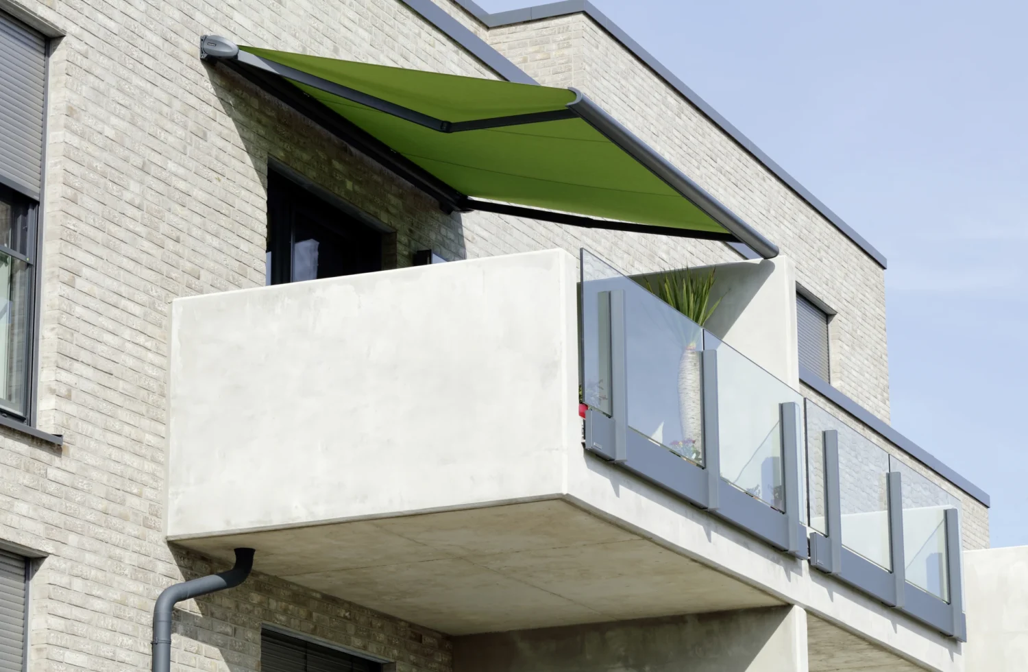 Grüne Markise an einer Steinwand mit Balkon