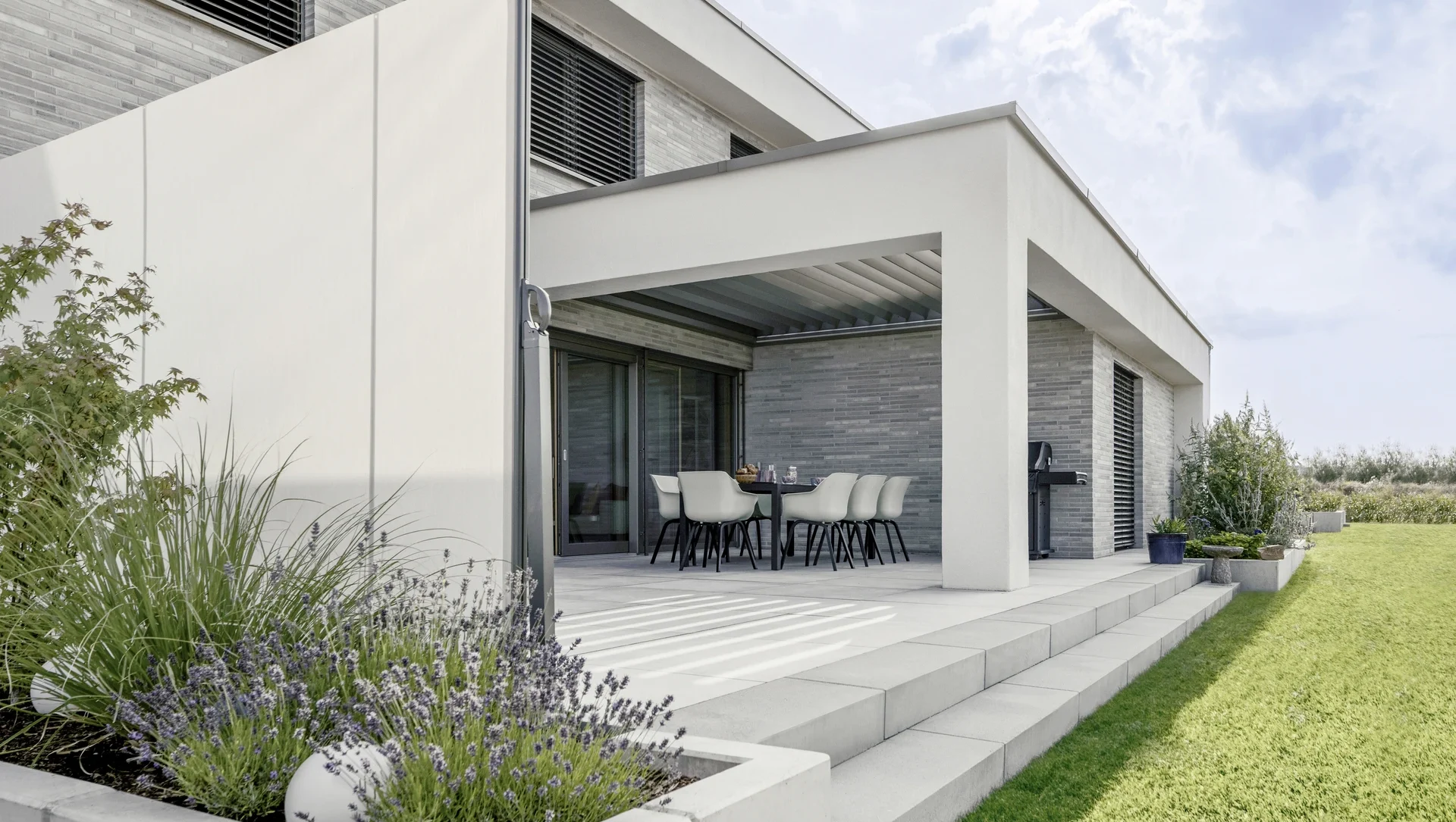 Moderne Terrasse mit Pergola und Garten