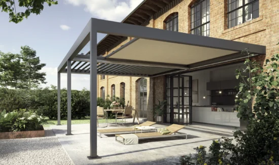 Modernes Terrassendach vor Backsteingebäude mit Gartenmöbeln und Pflanzen