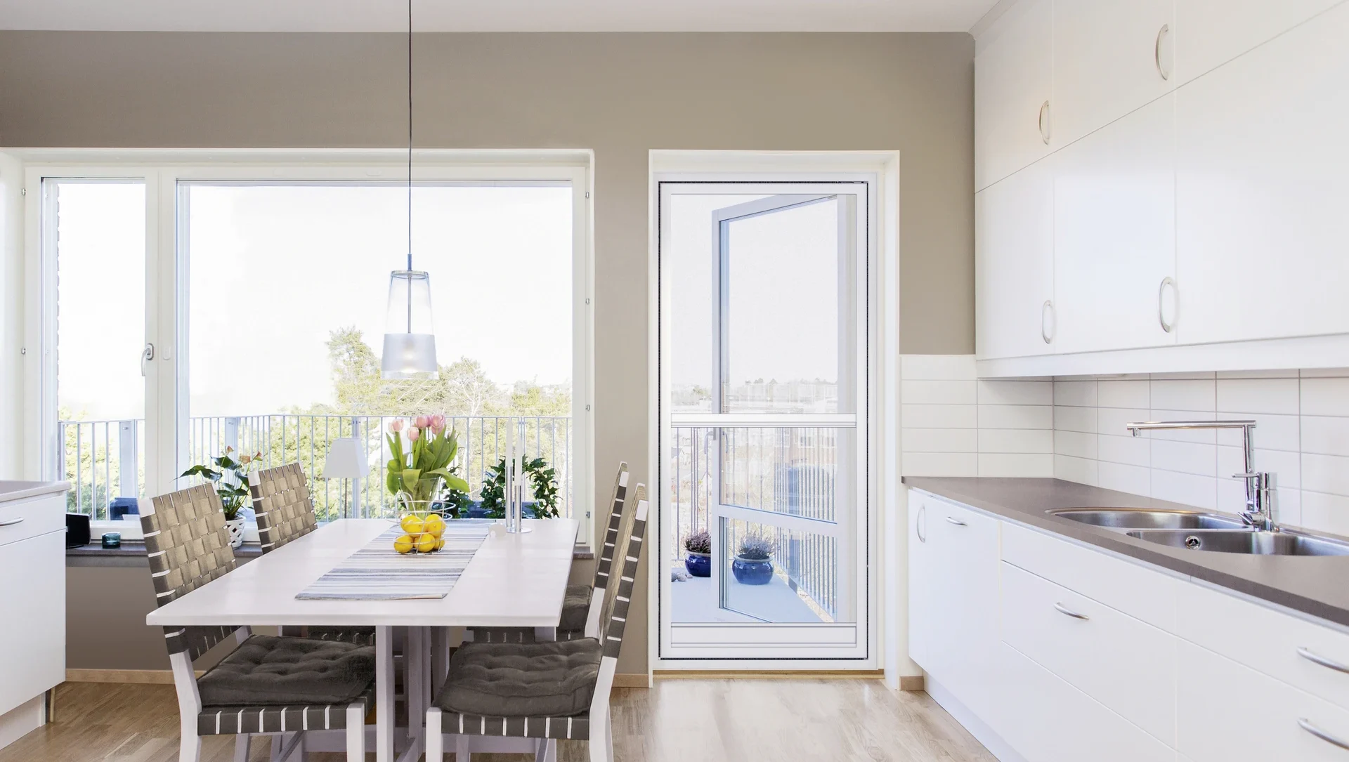 Moderne helle Küche mit Esstisch und großen Fenstern